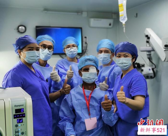 援助老挝的广西医疗队为当地患者完成复明手术后与患者合影。　黄惠滢 摄