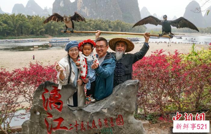 图为3月13日，游客与渔民模特在“20元人民币背景图”打卡处合影。　蒋丰慧 摄