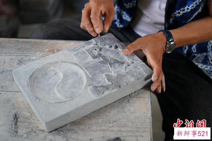 图为张跃堂正在雕刻白族民居主题的凤羽砚。　刘冉阳 摄