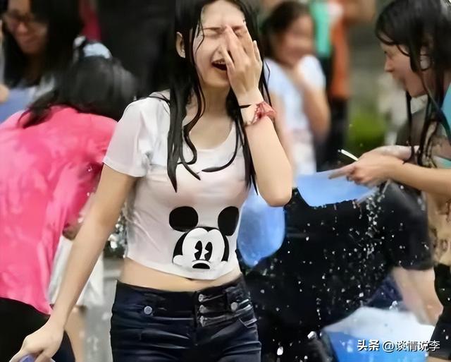云南泼水节不雅事件，女生生理期被撕雨衣，微胖女子被围攻