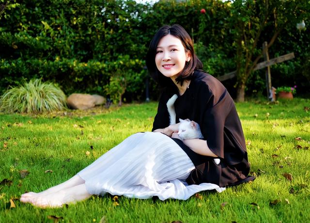42岁童蕾赤脚坐草地撸猫，穿百褶裙气质优雅，四肢纤细身材苗条